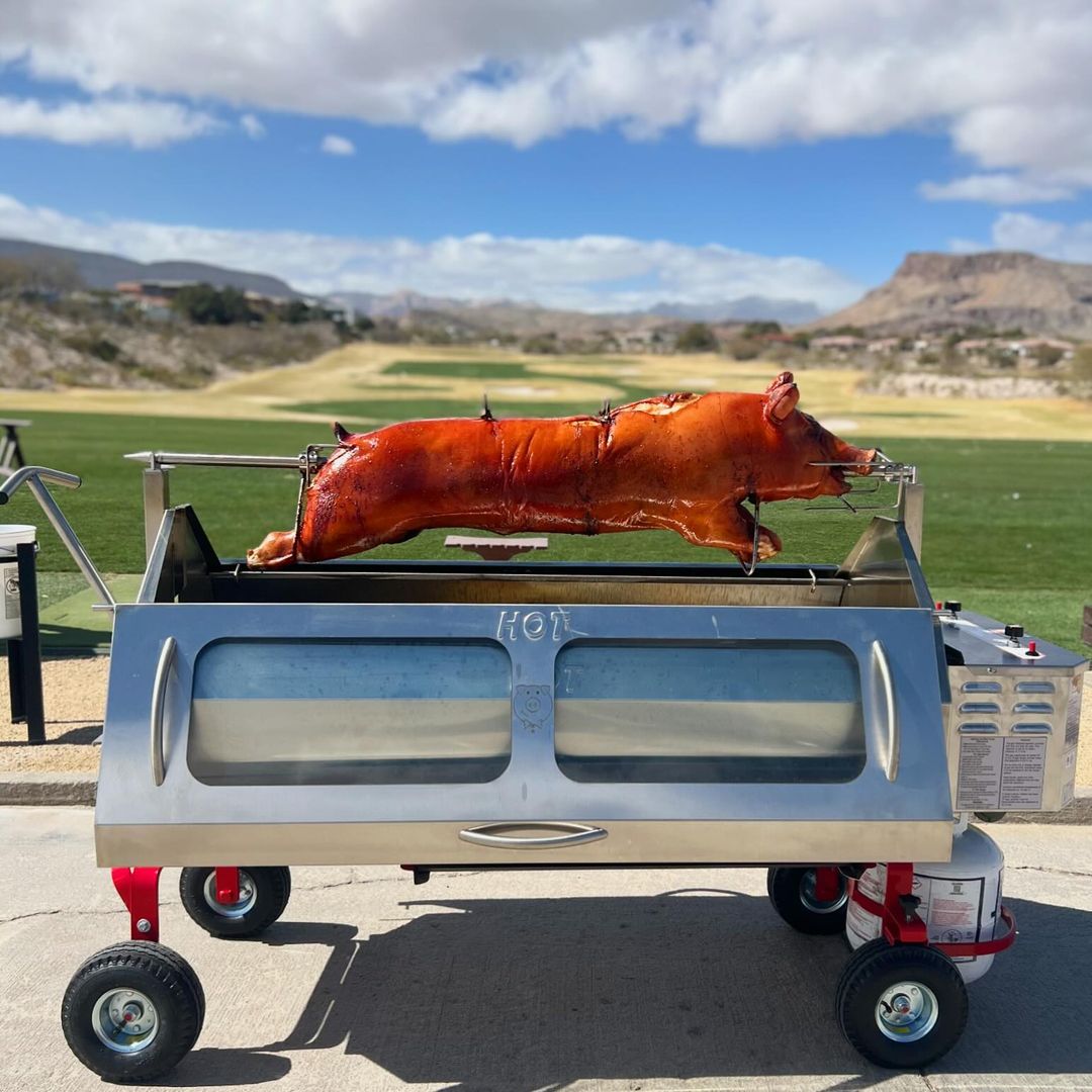 A PigOut Propane Roaster set up at a golf course event