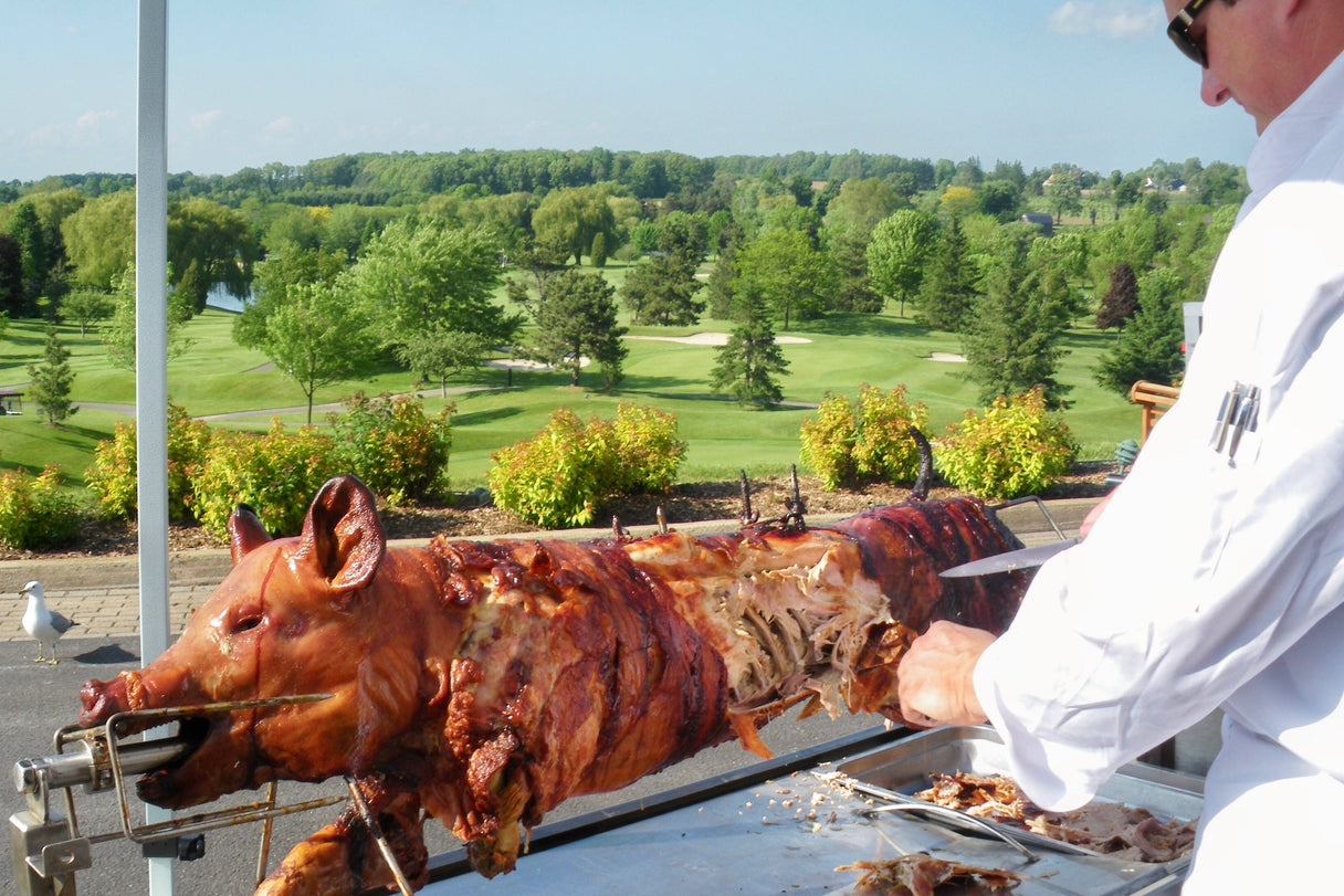 A whole pig being carved from a PigOut Roaster at a golf course event