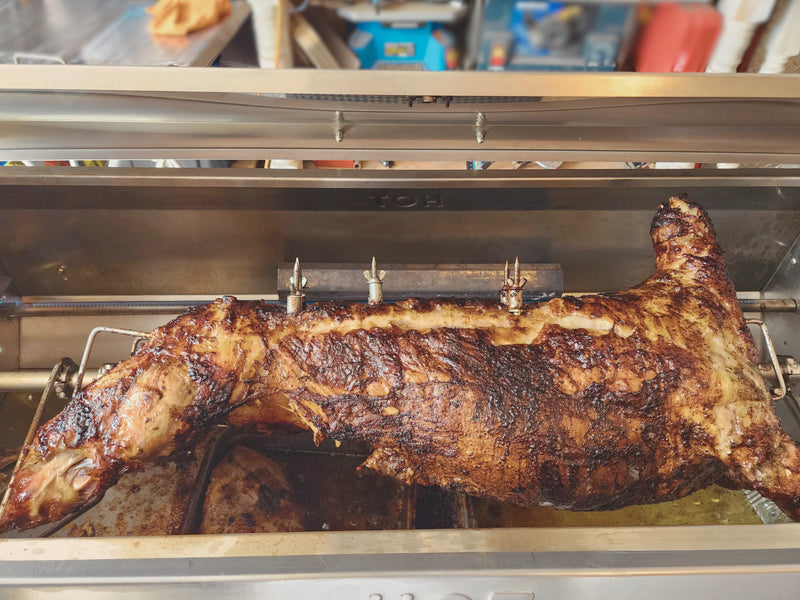 Whole roasted lamb on a propane rotisserie machine