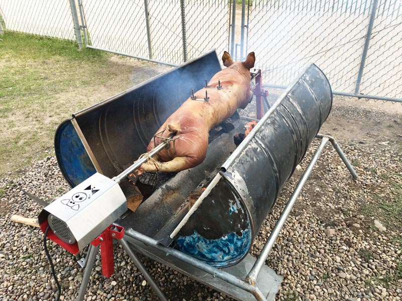 A charcoal rotisserie surrounded by a custom roaster