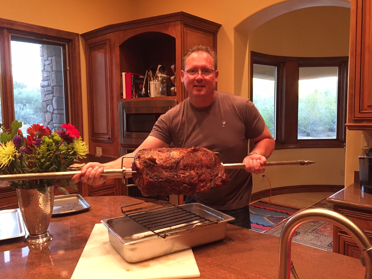 Man holding up the pole of a charcoal rotisserie