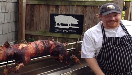 green bistro owner with a cooked pig