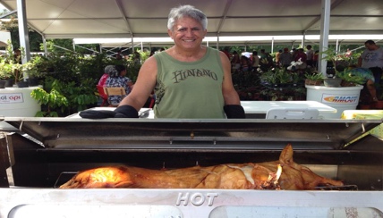 man standing in front of a roasted pig